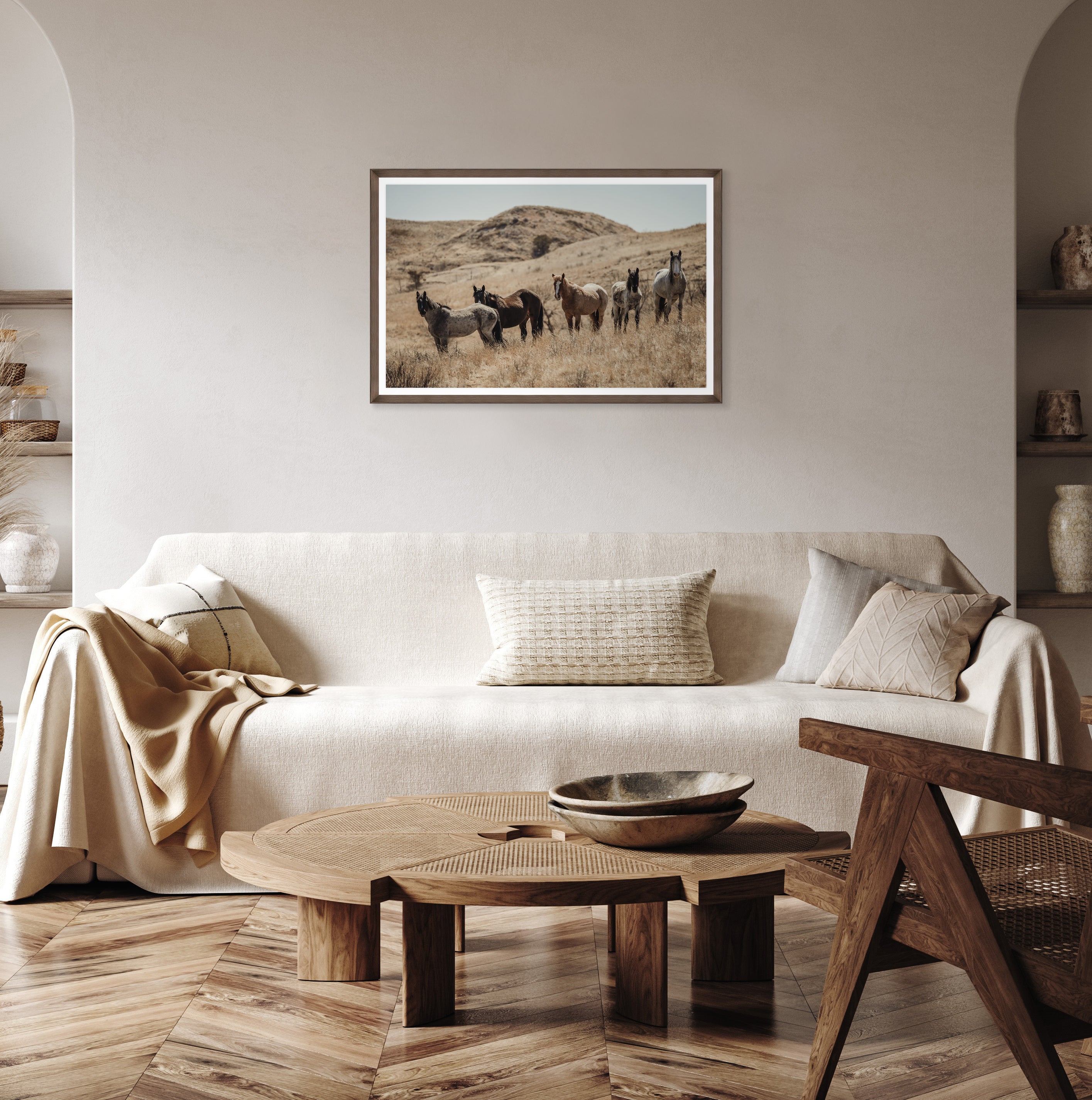 Living room with a beige sofa, wooden coffee table, and framed picture of horses on the wall - Your Western Decor