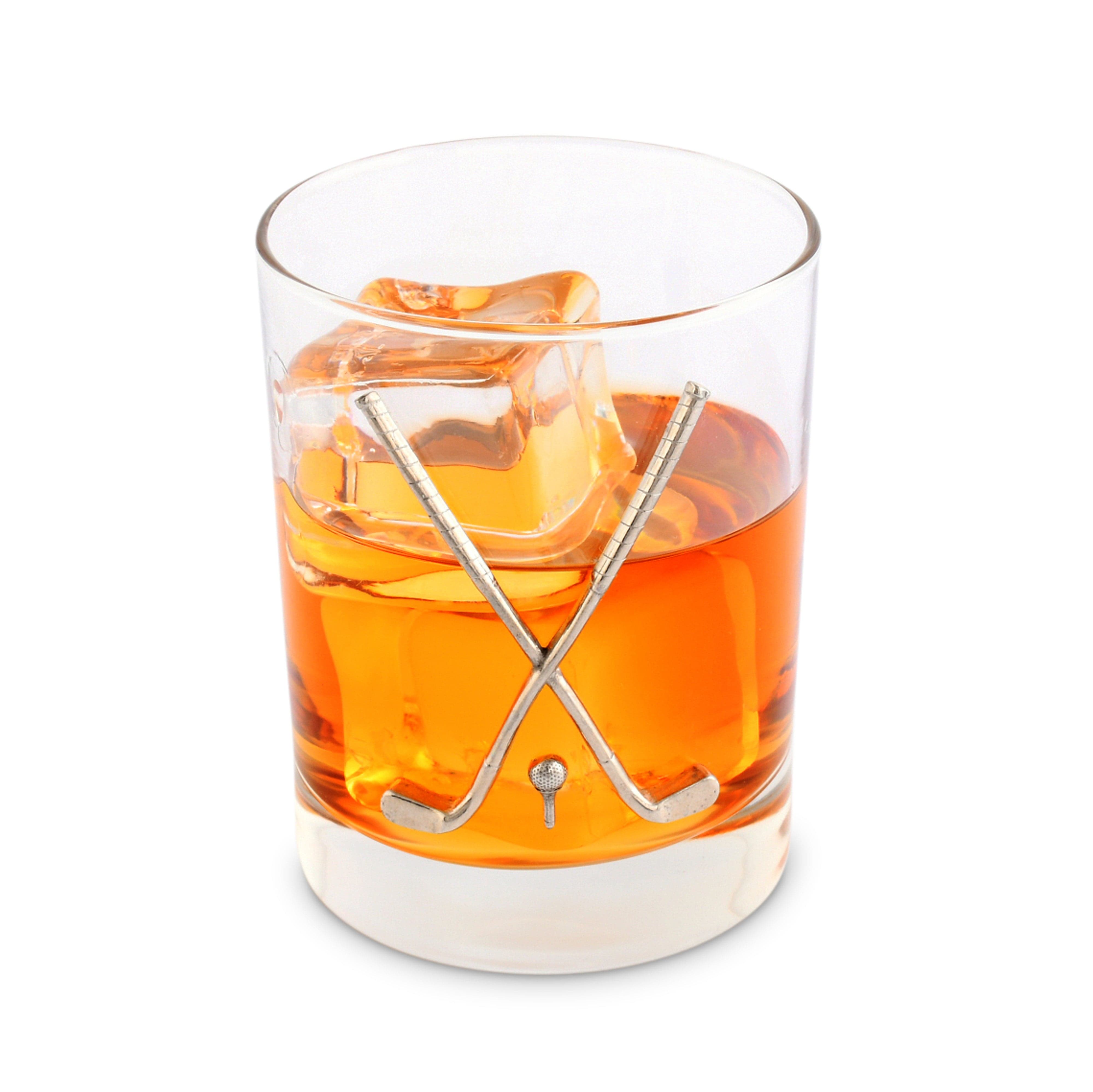 Glass of orange cocktail with ice and golf-themed stirrer on a white background