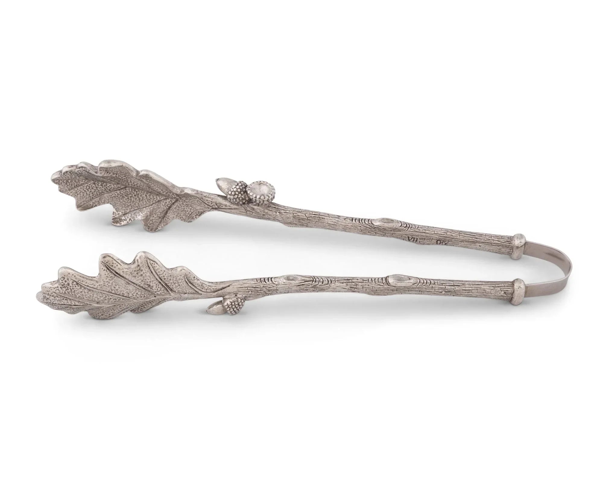 Decorative tongs with leaf and acorn design on a white background