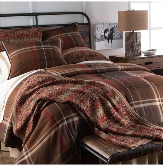 Brown lodge plaid comforter set styled in a luxury rustic resort bedroom with iron and wood bed, rustic lamp, and horse art