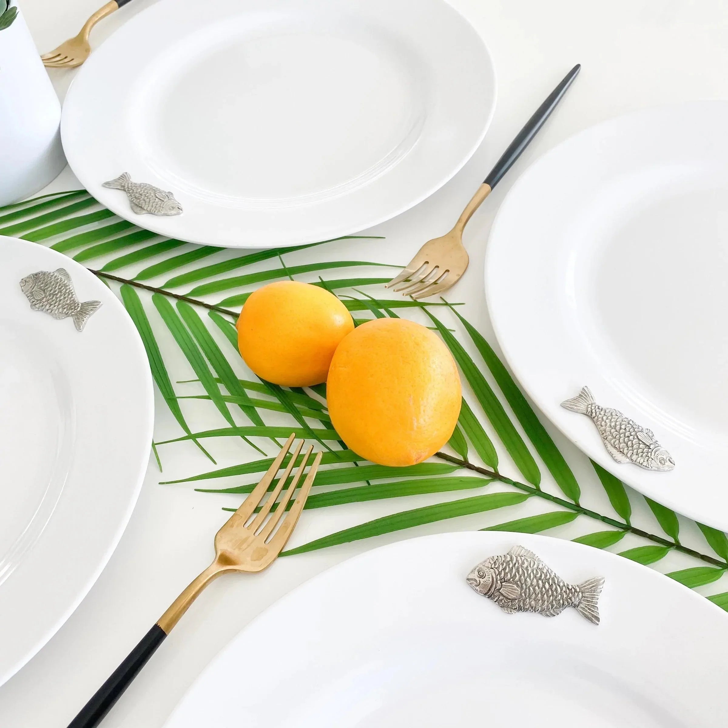 white melamine dinner plates with carved pewter fish on the rim - Your Western Decor