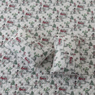 Quilt with Christmas-themed fabric featuring snowmen, trees, and houses.