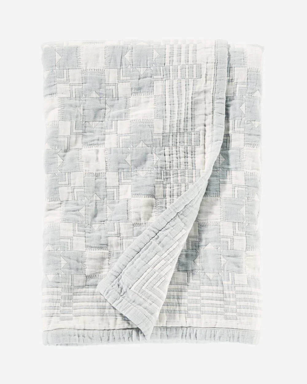 Textured light blue and white quilt with a geometric pattern on a white background