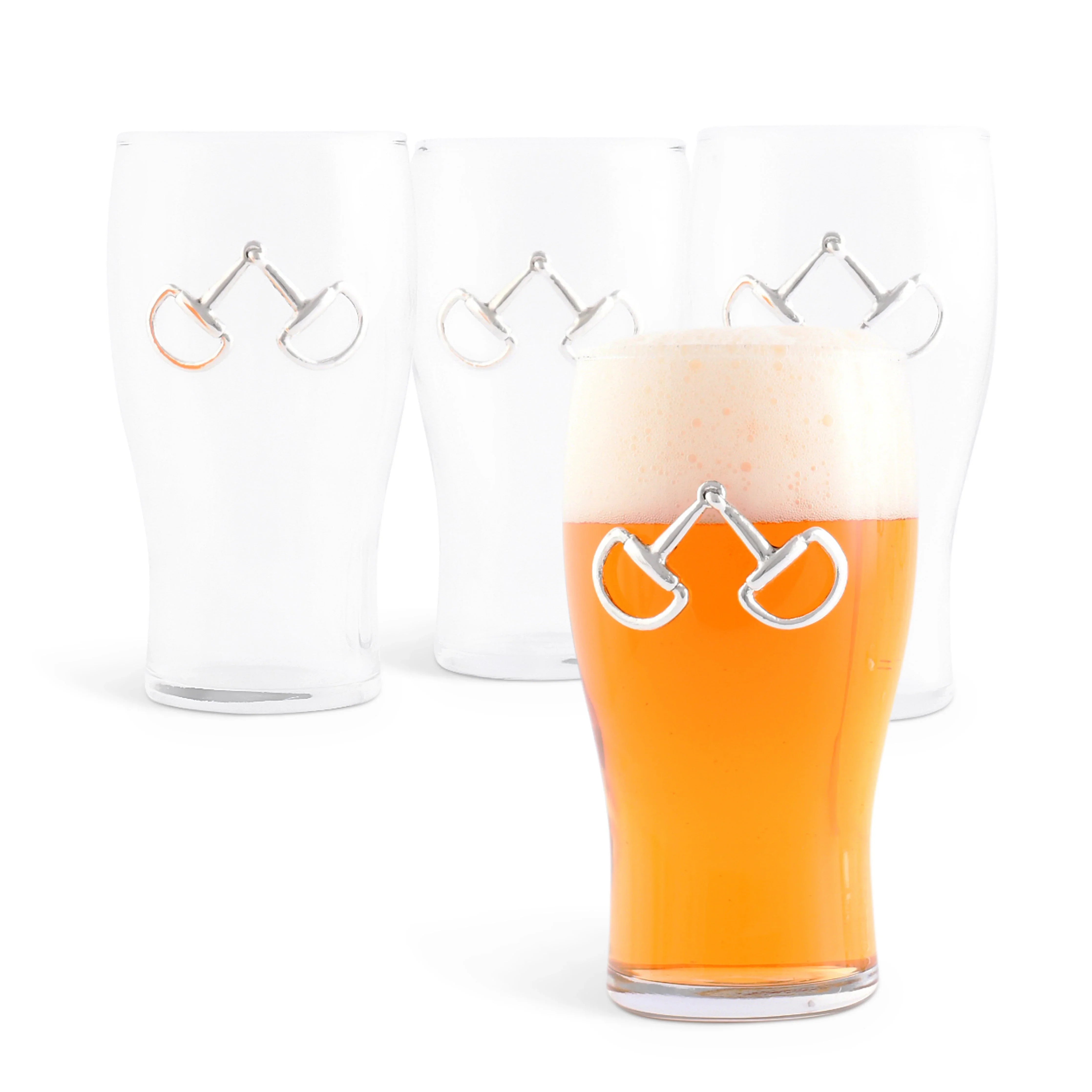 Clear glass with horse stirrup design filled with orange liquid on a white background
