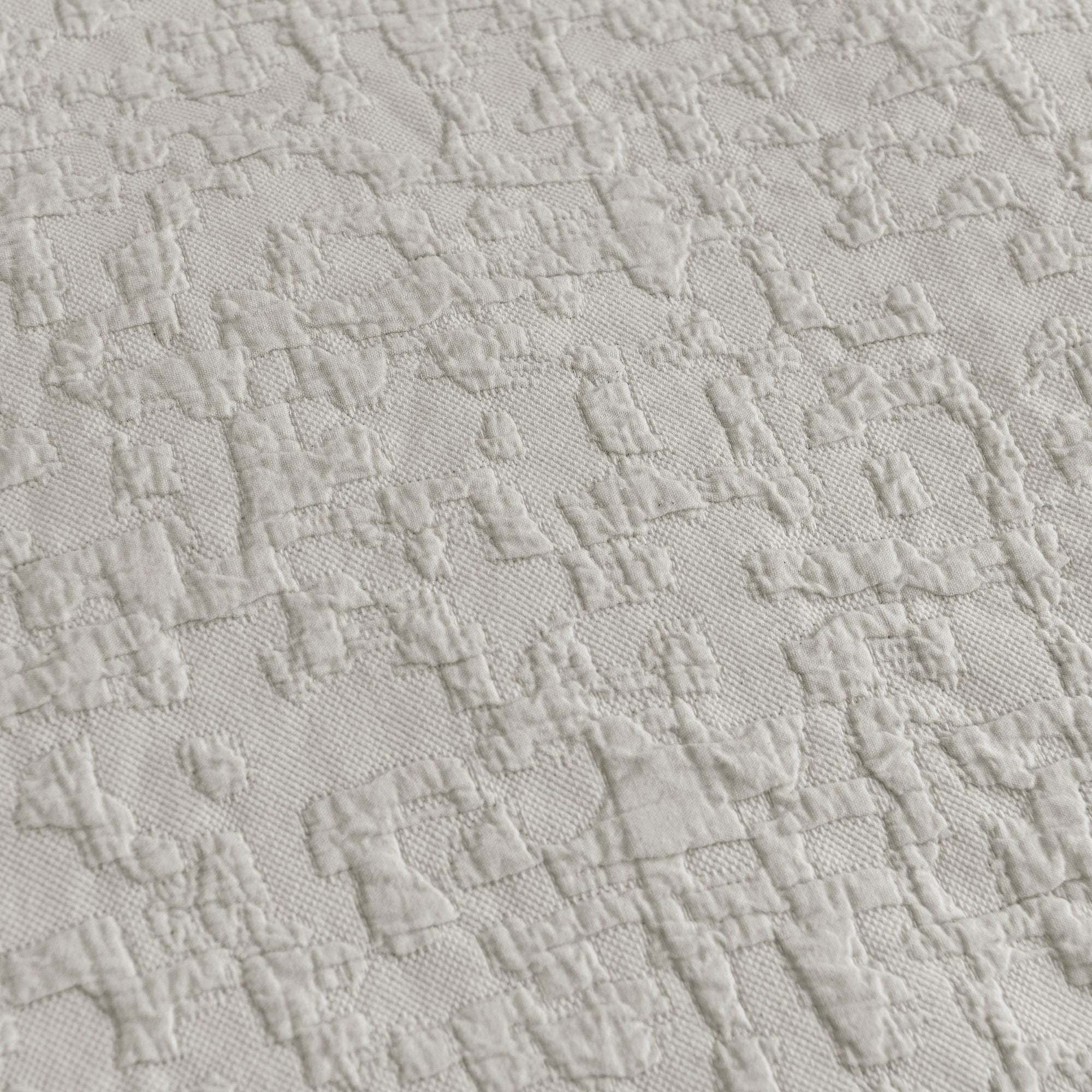Close-up of textured light gray fabric with a diamond pattern