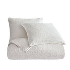 White textured comforter and pillow on a white background