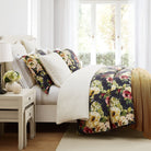 Floral-patterned comforter on a bed in a bright bedroom with natural light.