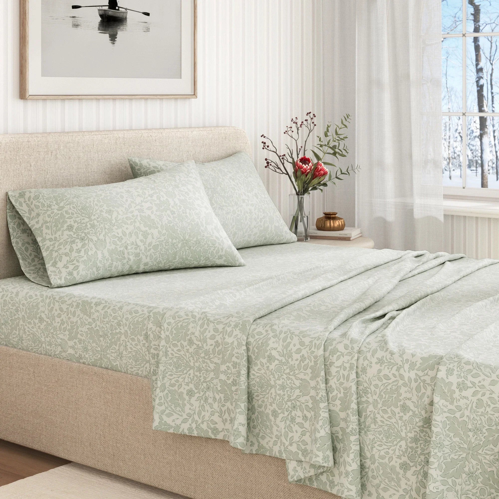 Bed with light green floral bedding and pillows in a bright bedroom.