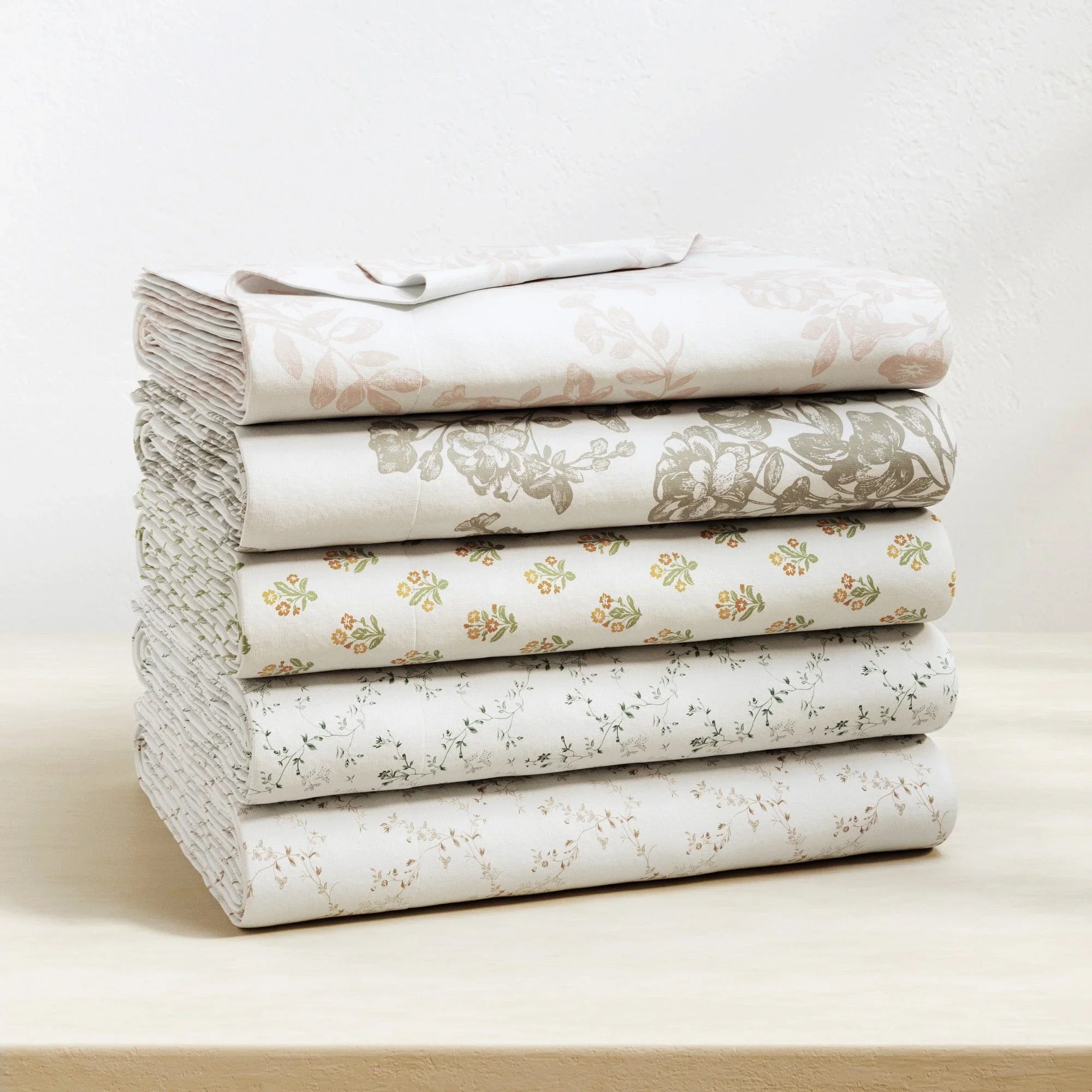 Stack of folded floral-patterned fabric on a light background