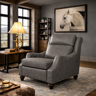 Storm grey leather power recliner with nailhead trim staged in a refined lodge-industrial living room with solid grey wall, framed white horse art, antler table lamp, bookshelf, and cowhide leather ottoman with whiskey tray.