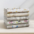 Stack of folded fabric sheets with animal patterns on a light surface.