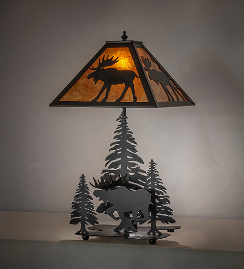 Rustic lone moose table lamp with amber mica shade and black forest silhouette base illuminated