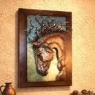 A framed wall art piece featuring a sculptural horse head with metal mane details, mounted on a textured beige wall above a small decorative vase and tray.