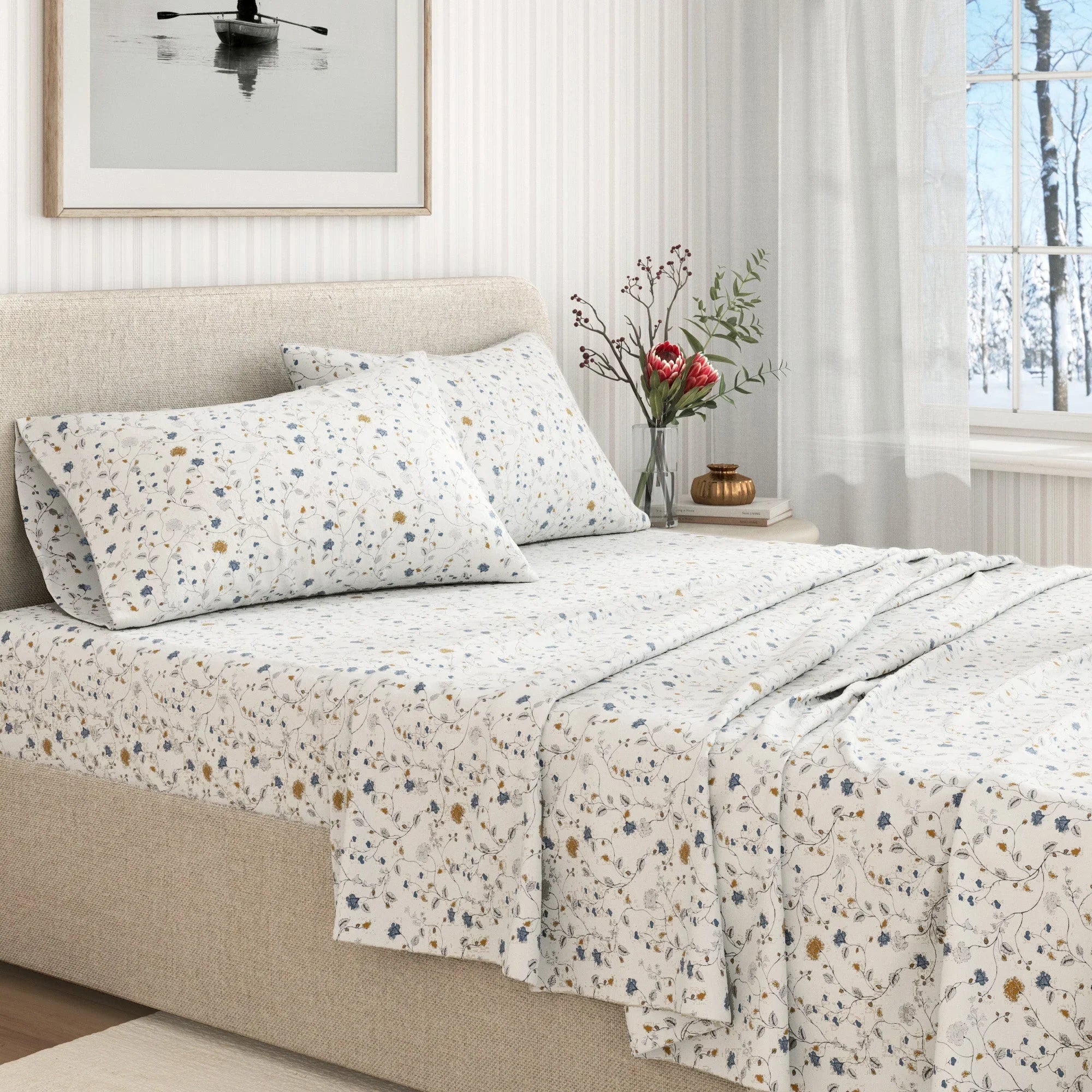 Floral patterned bedding set on a bed in a bright bedroom with a window and decor.