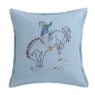 Embroidered pillow with a cowboy riding a horse design on a light blue background