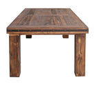 A rustic rectangular wooden dining table with a dark brown plank top, thick block legs, and dark metal trim with brass rivets along the front edge, shown against a plain white background.