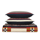 Quilt and pillows with geometric pattern on a white background