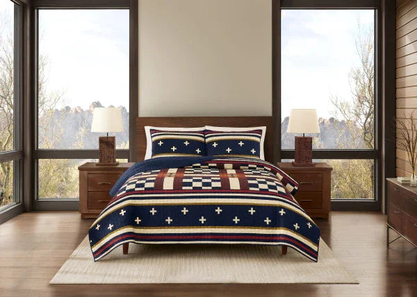 Bedroom with a bed featuring a red, white, and blue patterned comforter.
