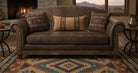 Brown leather sofa with patterned cushions in a cozy living room setting.
