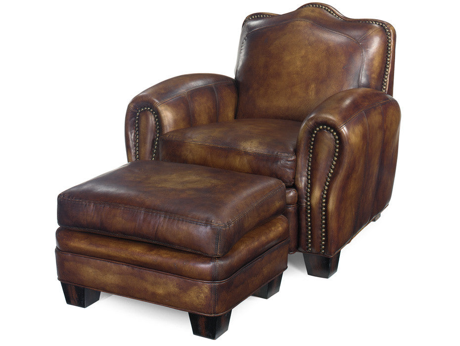 A classic brown leather recliner chair with an attached matching ottoman, featuring rolled arms, nailhead trim, and dark wooden legs, shown against a plain white background.