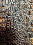 Close-up of crocodile skin texture in two-tone brown with copper metallic