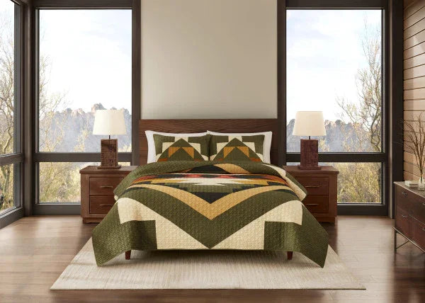 Bedroom with a bed featuring a geometric patterned comforter, wooden nightstands, and large windows.