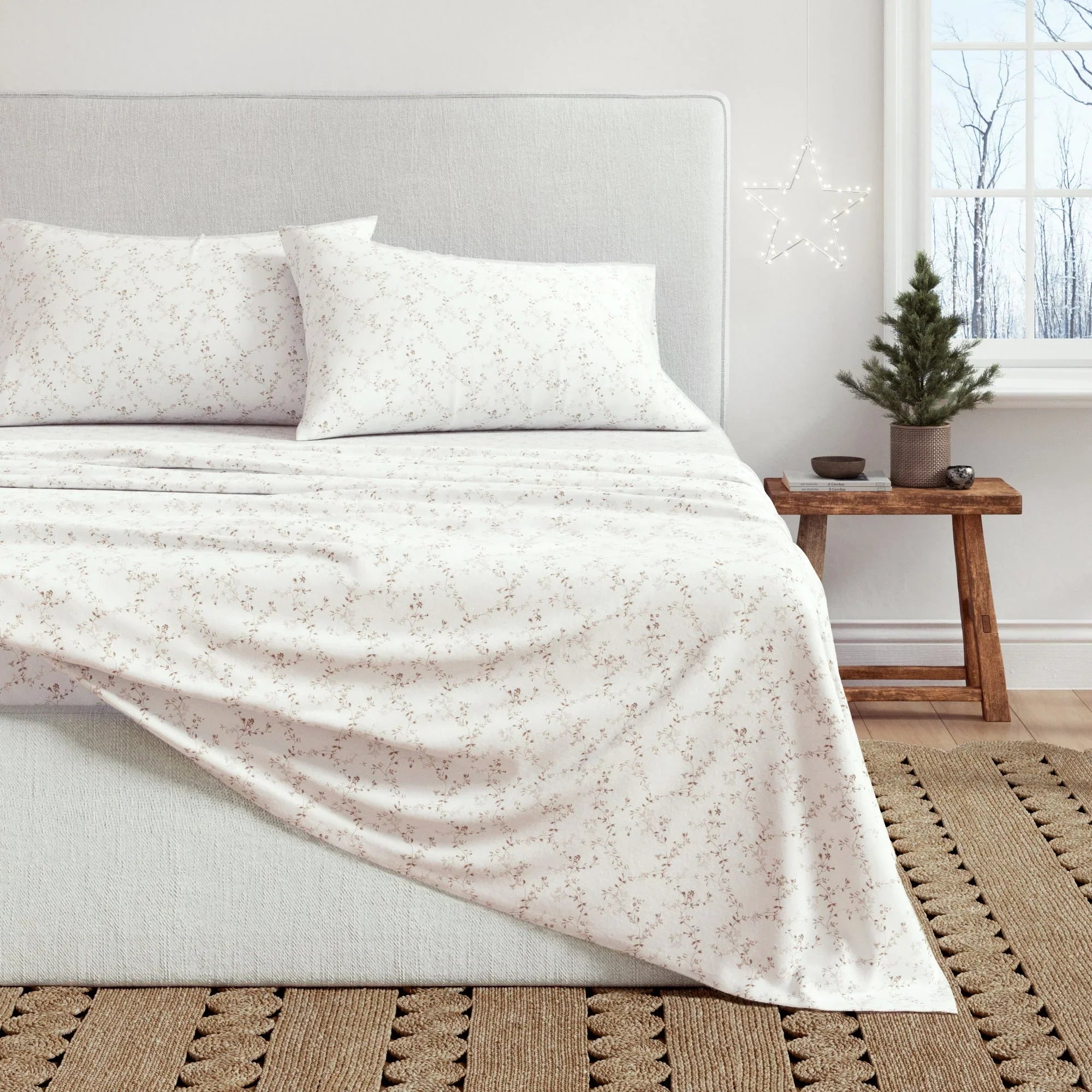 Neatly made bed with a light-colored comforter in a bedroom setting.