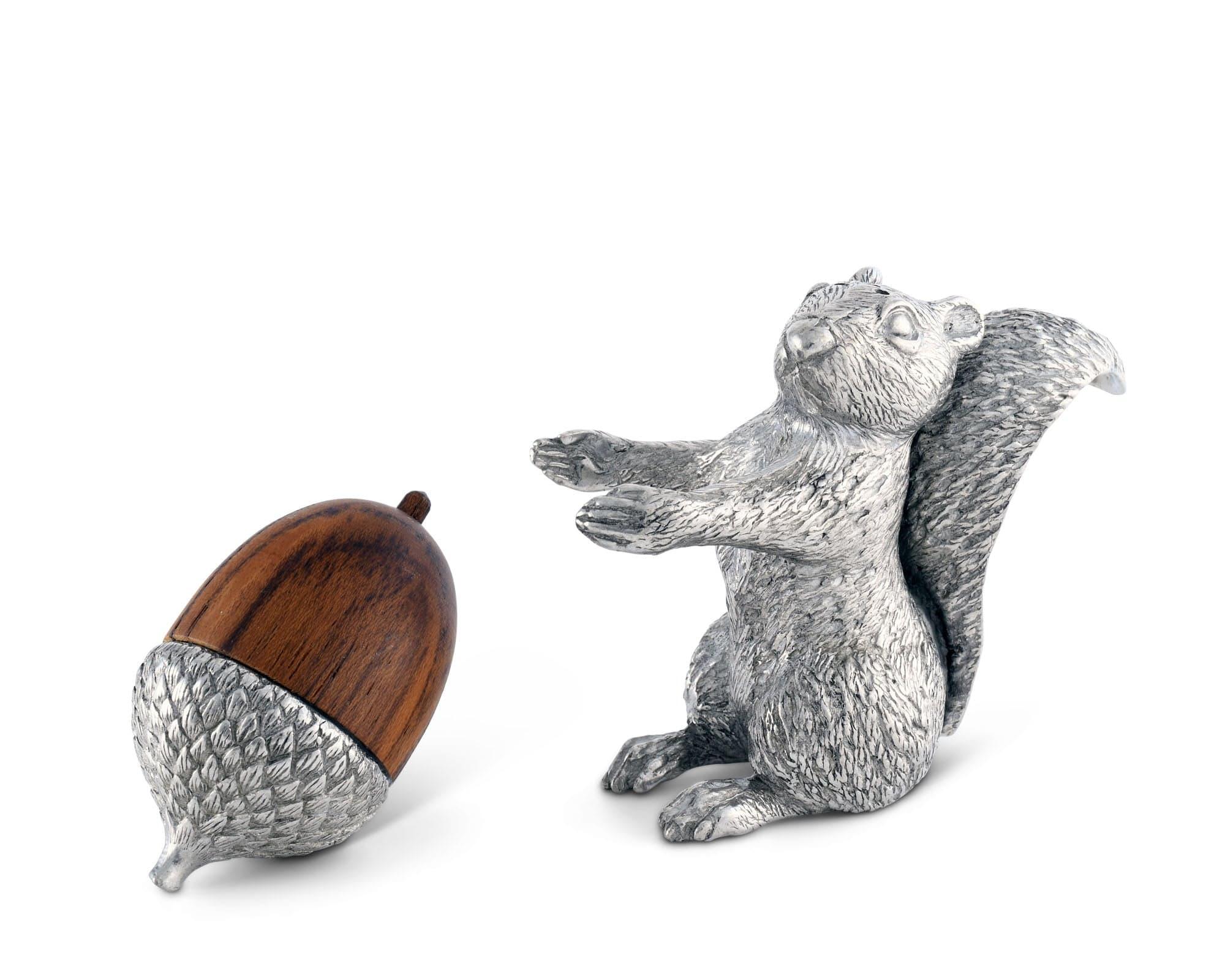 Silver salt shaker squirrel figurine with a wooden pepper shaker acorn on a white background
