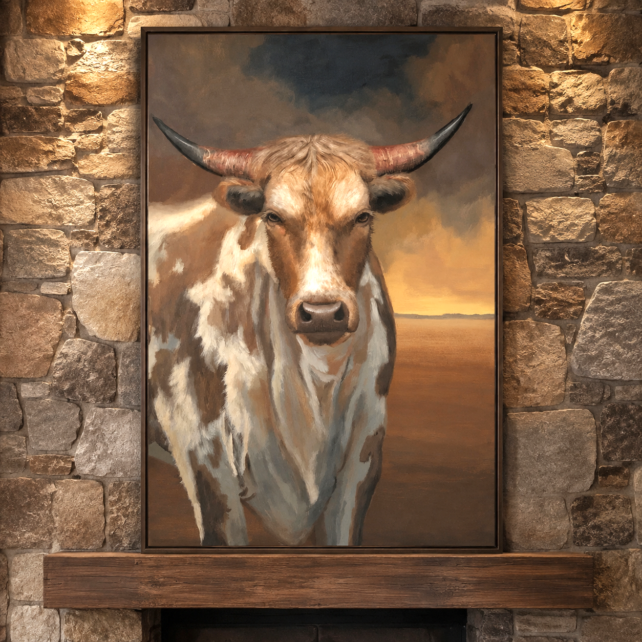 A framed vertical canvas painting of a longhorn steer with brown and white patches, displayed on a rustic stone wall above a wooden mantel.