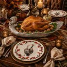 Handmade aluminum turkey serving tray holding a whole roasted Thanksgiving turkey. Shown with Northwoods dinner plates