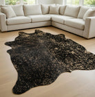 black cowhide rug with metallic gold acid wash accents in modern living room
