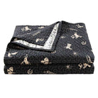 Black quilt with cowboy-themed pattern on a white background