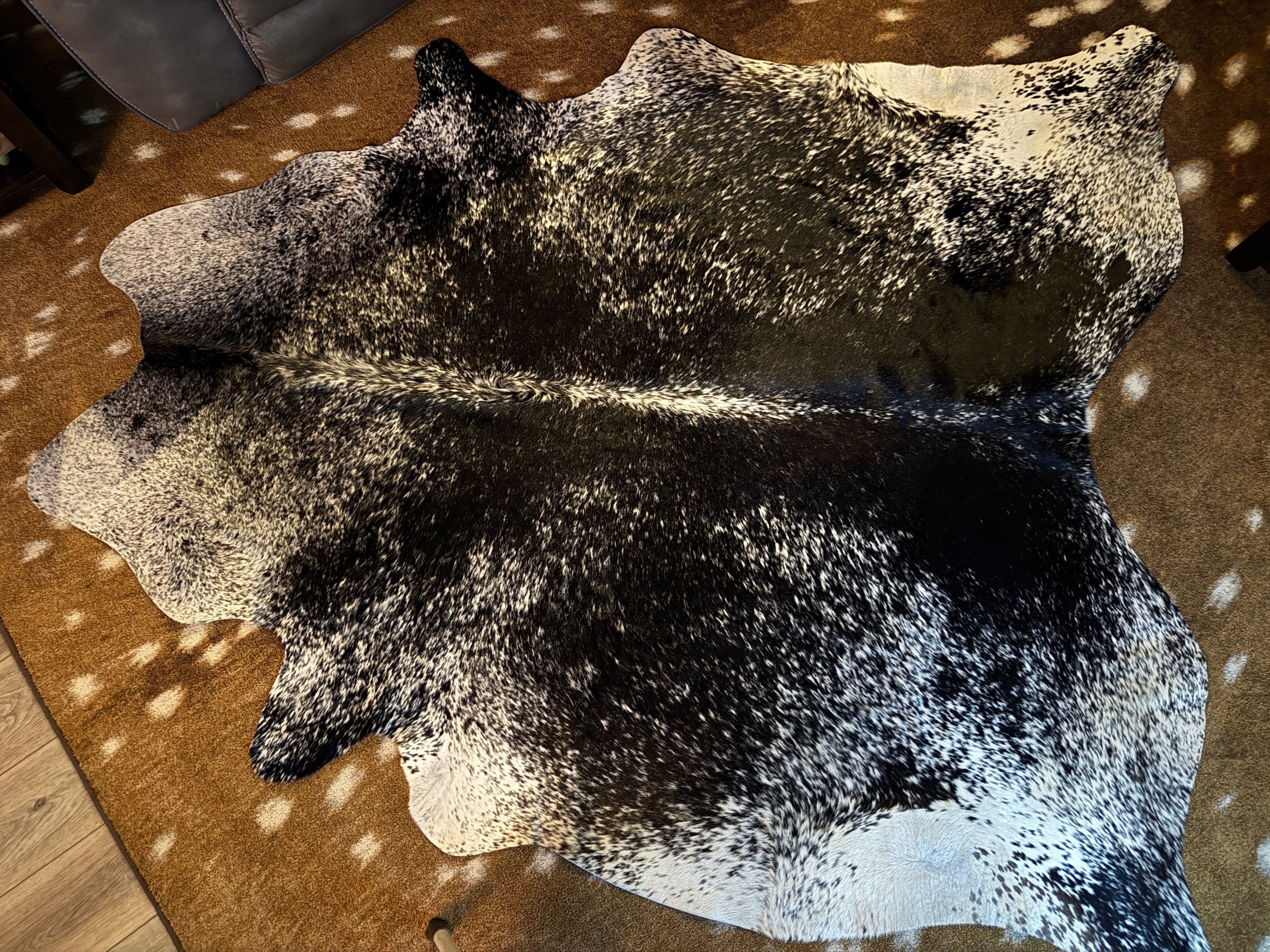 Black and white peppered cowhide rug over Axis deer hide print rug - Your Western Decor