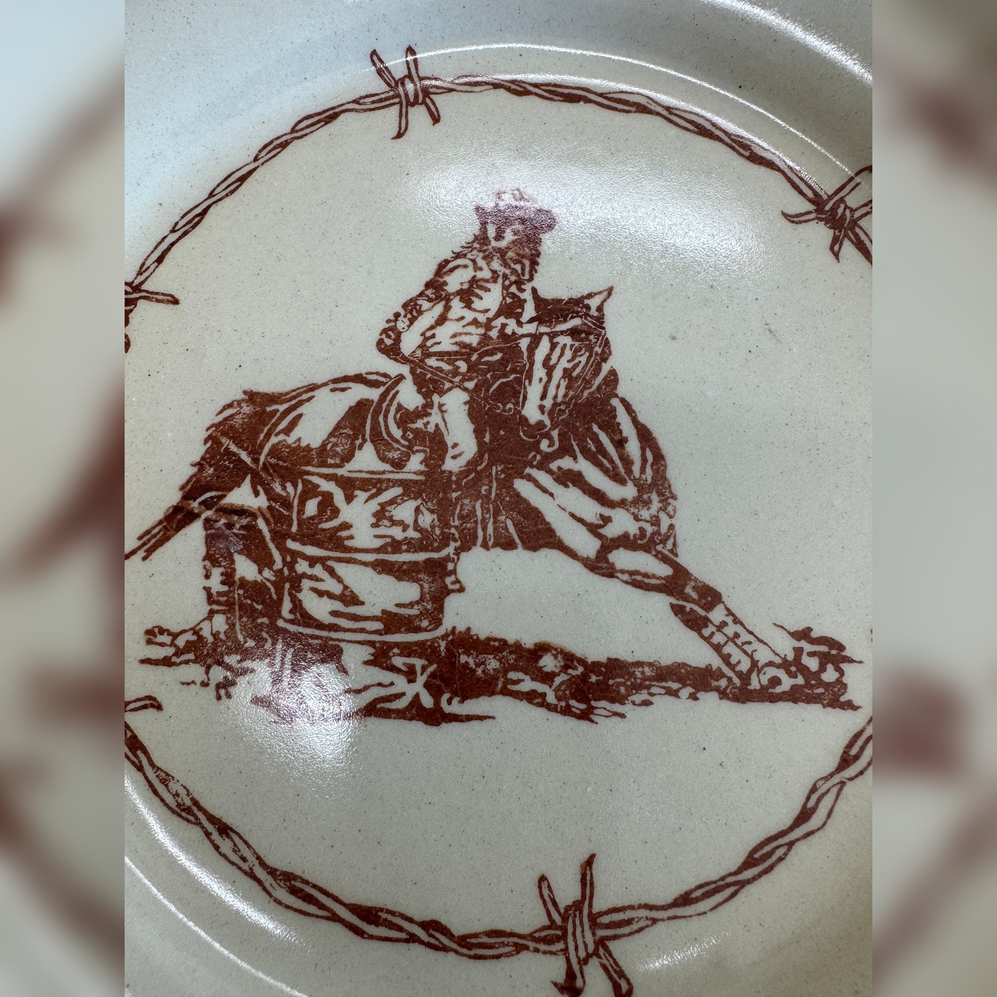 Blue Mountain Brands salad plate in warm ivory featuring a Pendleton Round Up barrel racer center with barbed wire surrounding
