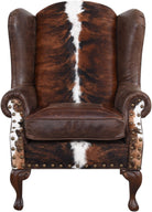 Wingback chair with brown and white cowhide pattern and studded details - Your Western Decor