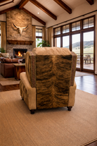American made Western leather recliner with brindle cowhide sides and nailhead trim back view displayed in bright open ranch home with high ceilings and large windows