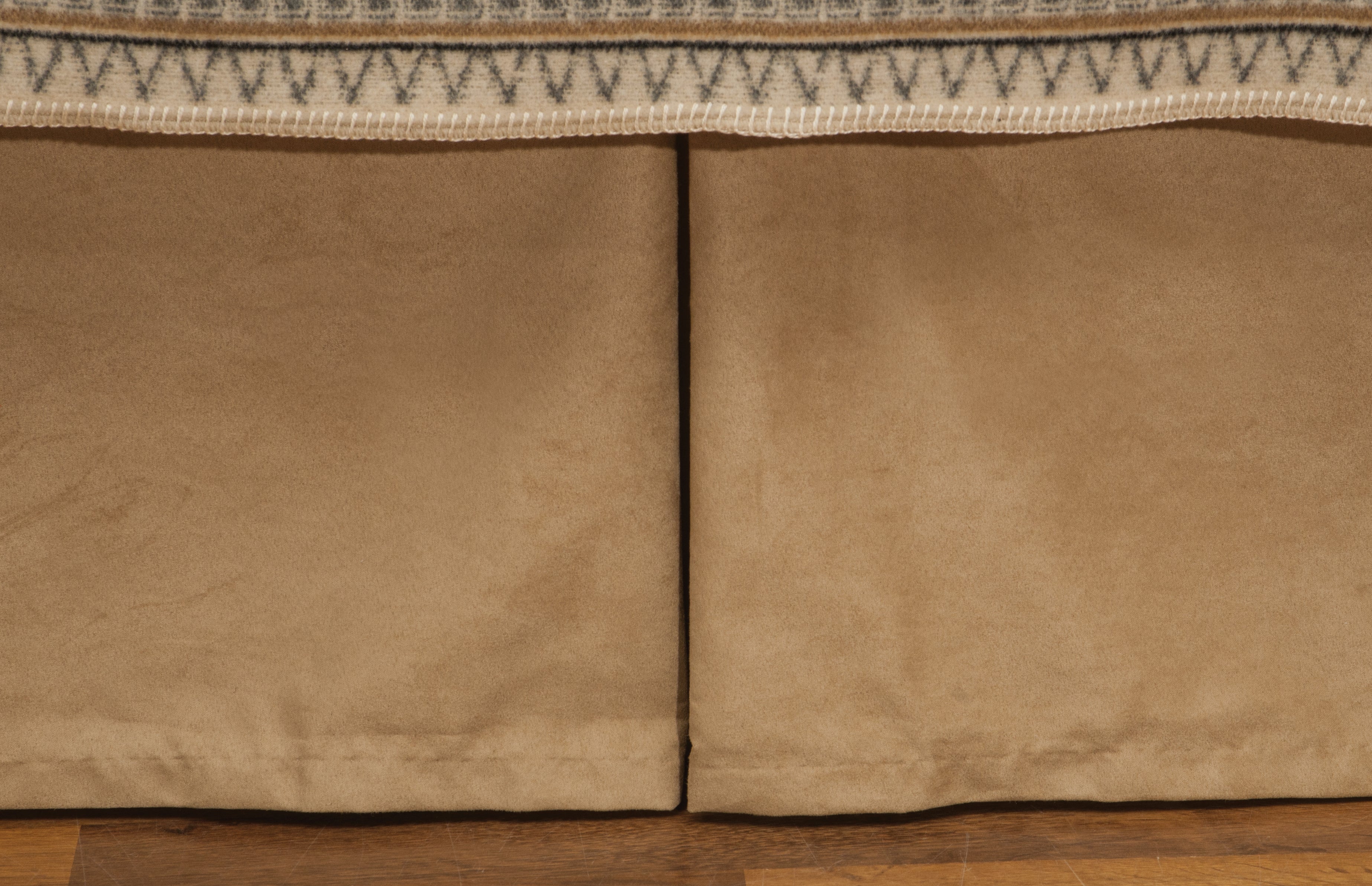 Fawn suede bed skirt in warm neutral tone with tailored pleats, soft western bedding accent in rustic lodge bedroom setting