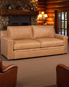 Brown sofa in a cozy living room with wooden walls and a fireplace - Your Western Decor