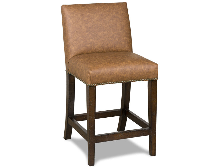 A counter-height bar stool with a brown faux-leather upholstered seat and backrest, supported by a dark brown wooden frame with a nailhead trim accent.