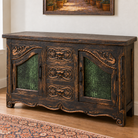 Canyon sideboard with distressed dark wood, hand-carved scrollwork, green croc-embossed leather door panels, and three center drawers.