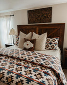 Bedroom with wooden headboard, patterned bedding, and decorative pillows - Your Western Decor
