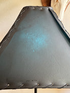 Close up of teal rawhide lamp shade with light on 