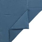 A close-up of a folded dusty blue fabric, showing the texture and hemstitching details against a plain white background.