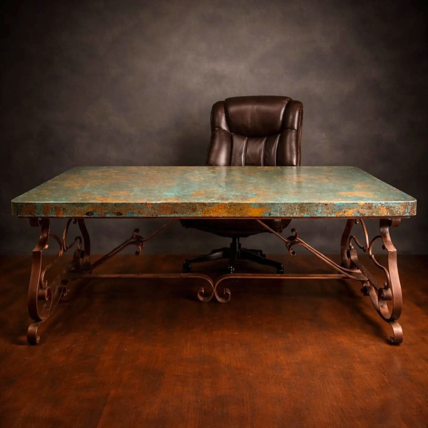 A rustic conference desk with a distressed copper patina top and ornate forged iron legs, paired with a dark brown leather office chair against a dark textured studio backdrop.