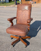 Custom made cowboys work day western leather office chair with embossed leather yoke in outdoor setting