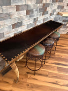 Custom made longhorn leg and cowhide sofa table and leather and iron counter stools 