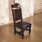 Brown leather chair with cowhide backrest in a room with beige carpet and brick wall - Your Western Decor