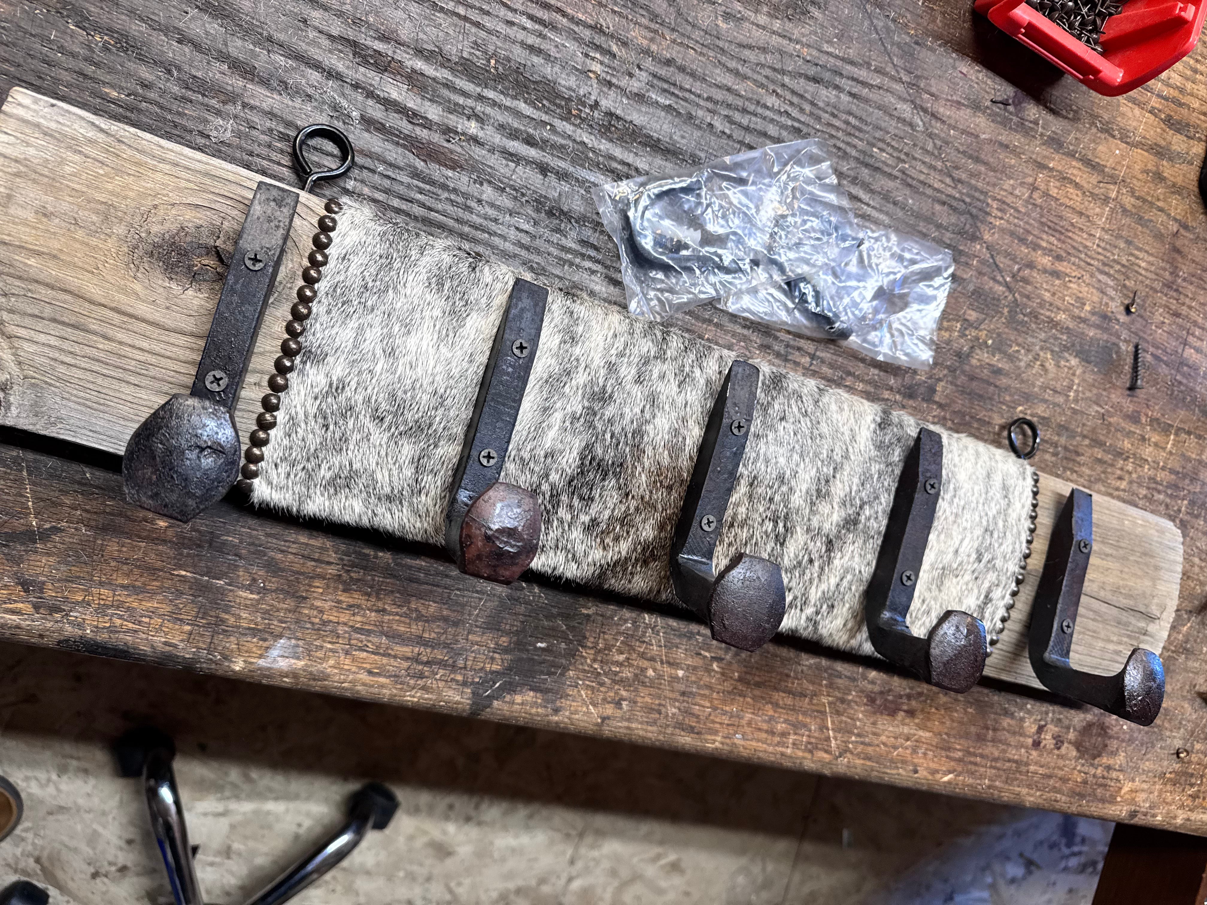 Custom made wall rack with railroad tie hooks and cowhide - Your Western Decor