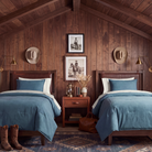 A rustic bedroom set featuring two twin beds with denim blue cotton comforters and off-white sheets, set against a dark wood-paneled wall with framed western art, cowboy hats, and brass wall sconces.