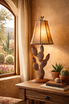 Decorative lamp shaped like a cactus on a wooden table with a window view of cacti outside - Your Western Decor